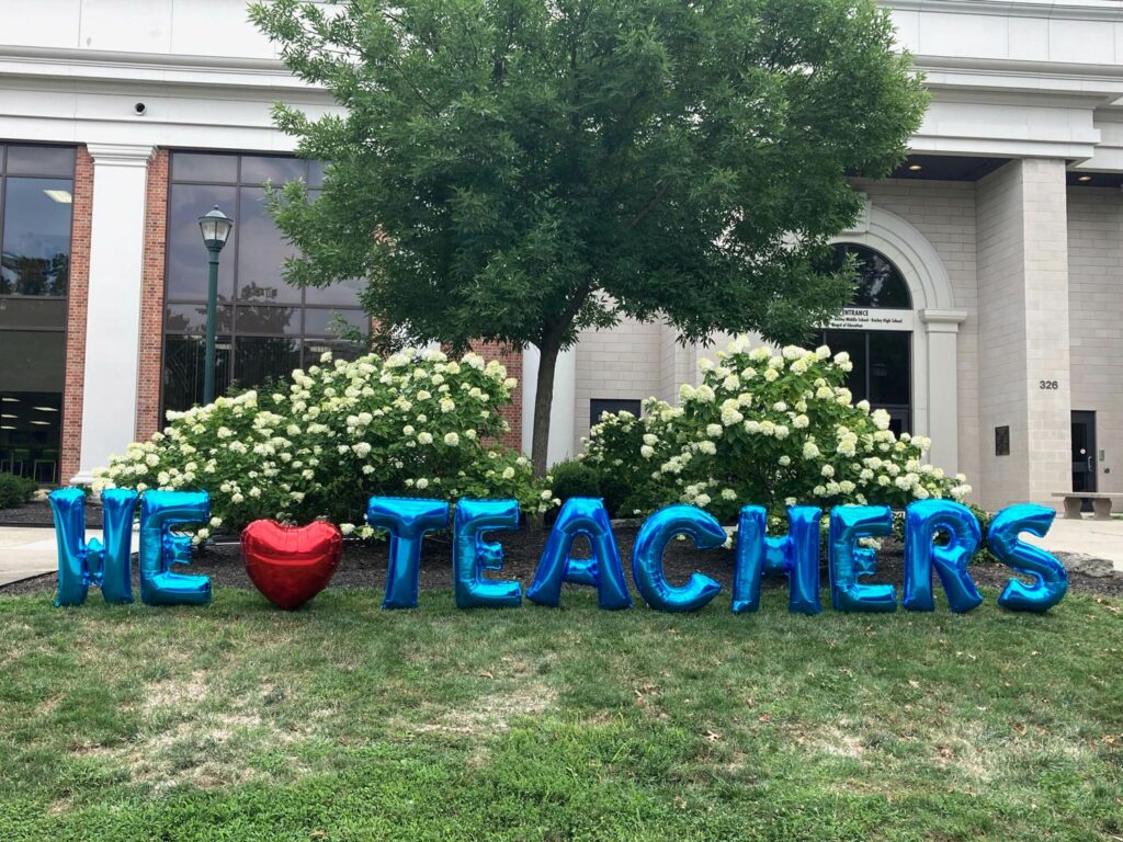 Mylar letter balloons outside a school that says "We heart teachers"