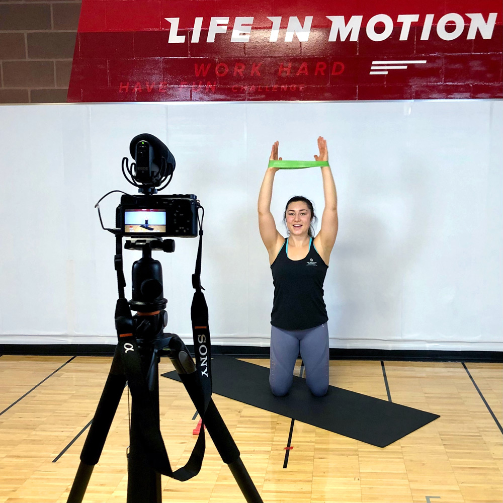 Fitness instructor records workout using resistance bands