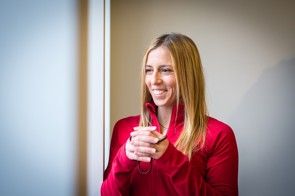 Julie Kennel gazes out a window while clasping her hands at chest level