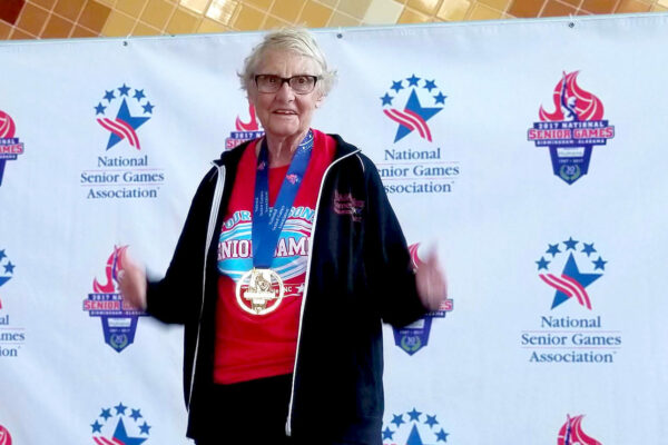 Alumna Pat Dockendorf gives two thumbs up after winning a medal at the National Senior Games