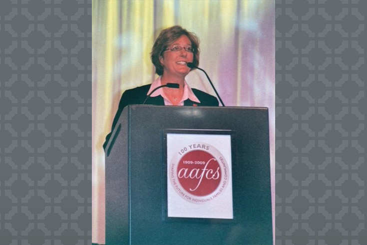 Woman at podium speaking at a conference