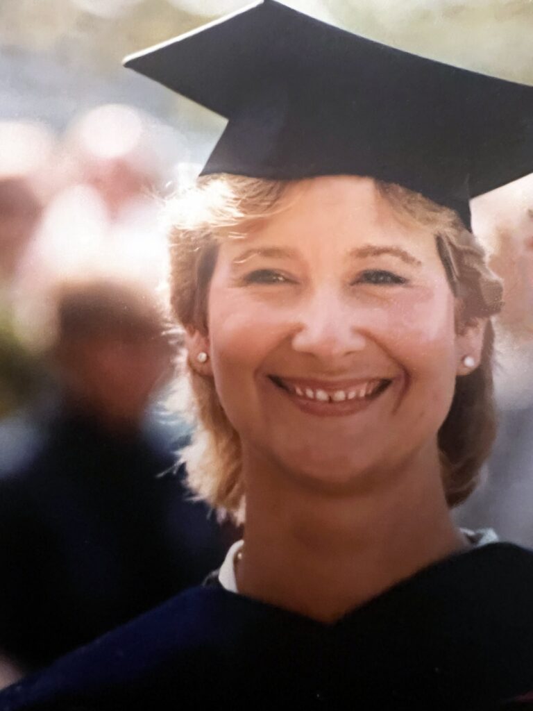 Sue Fitzsimons in graduation cap and gown from her PhD program.