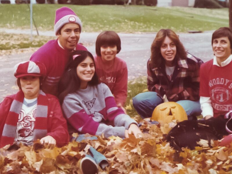 Weiler family photo sitting in leaves in the yard wearing Ohio State clothing.