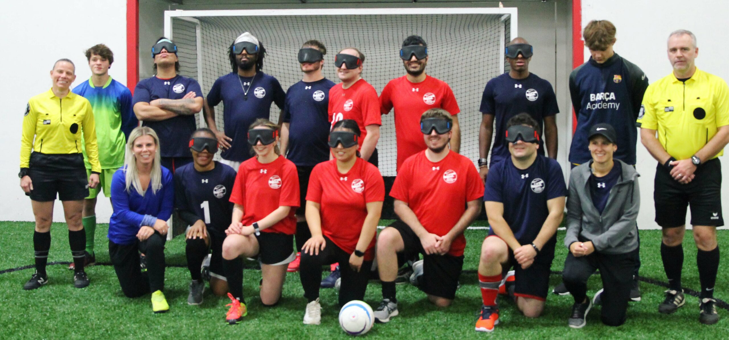 Katie Smith posing with blind soccer team in front of goal