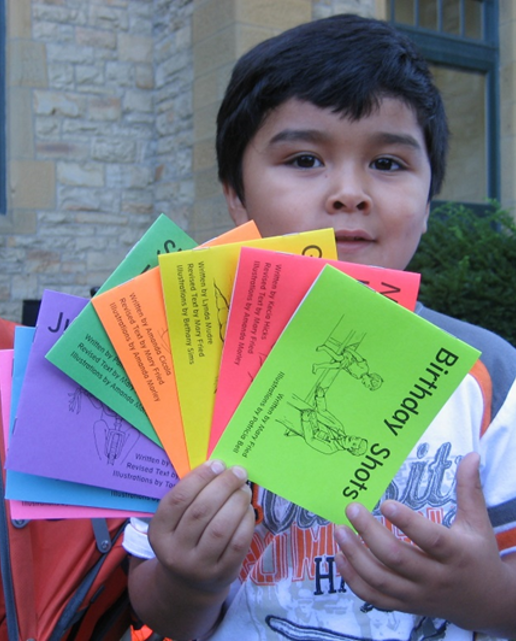 School age child holding several books from KEEP BOOKs fanned out
