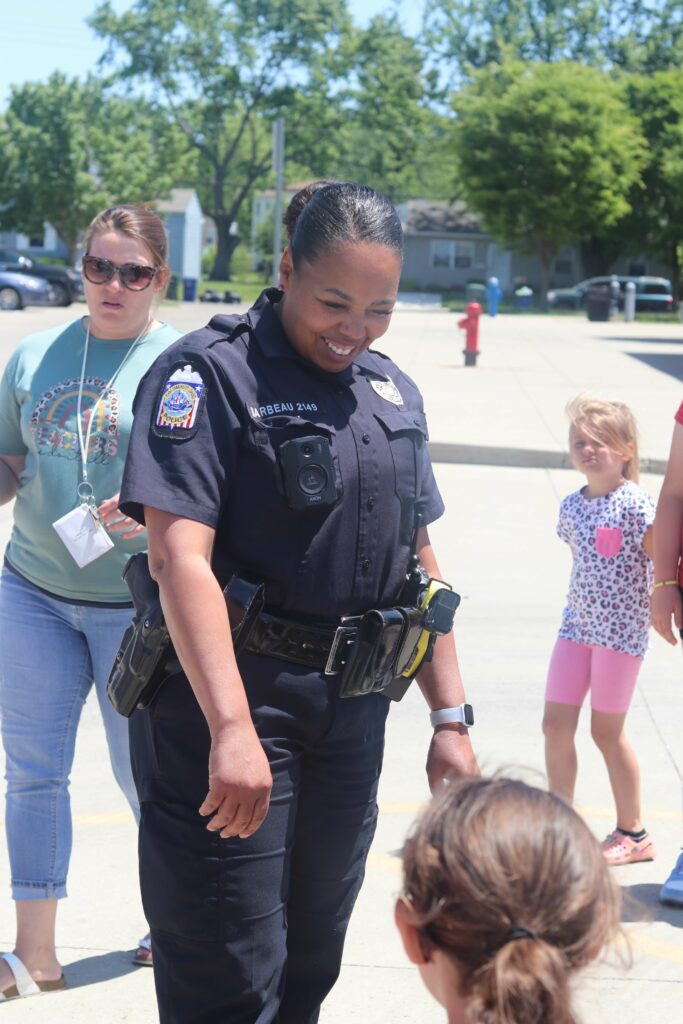 Female police officer talking to young school children on a sunny day