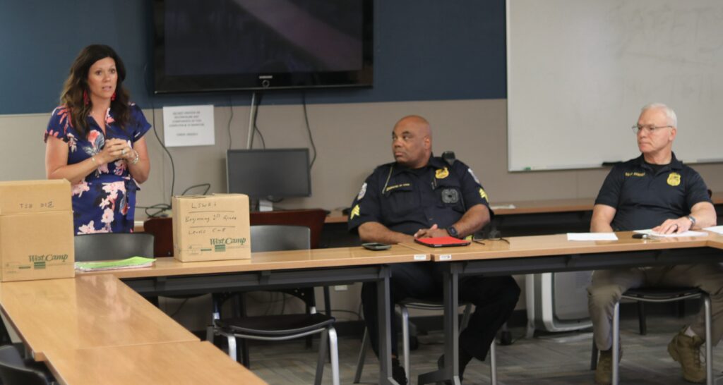 Teacher speaking to a group of police officers in a conference room