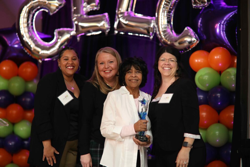 Gina Ginn with 3 other members of the Leadership Team presenting an award at a gala.