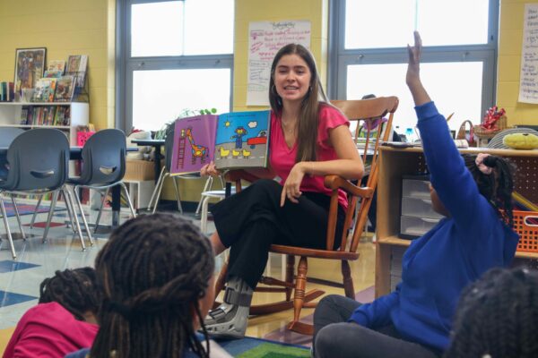 Teacher Zoe Lightcap reading to a group of young students