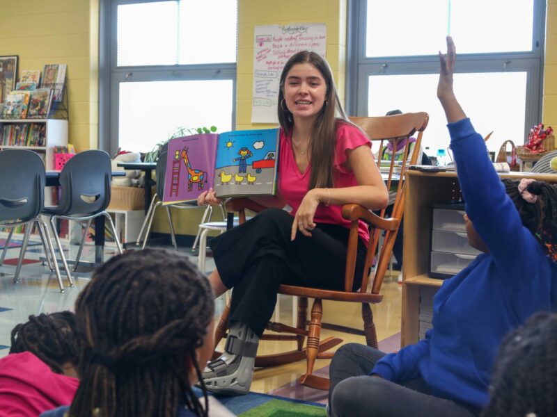 Teacher Zoe Lightcap reading to a group of young students