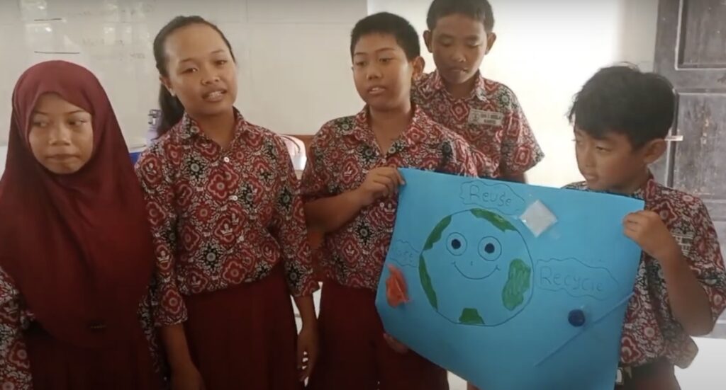 Indonesian students presenting a poster they created in class.