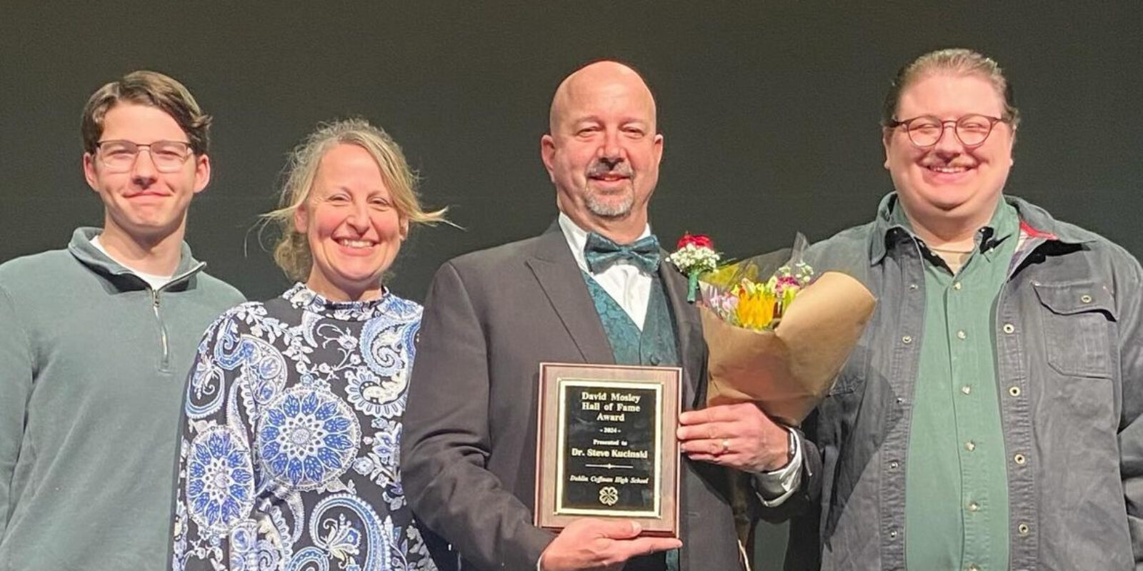 Steve Kucinski receiving an award with his family on stage