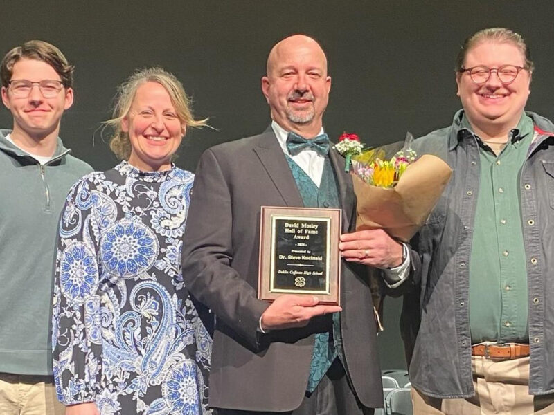 Steve Kucinski receiving an award with his family on stage