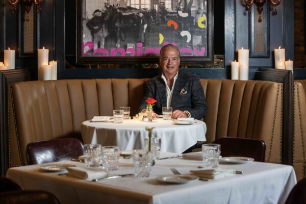 Cameron Mitchell sitting at a table in one of his Columbus restaurants